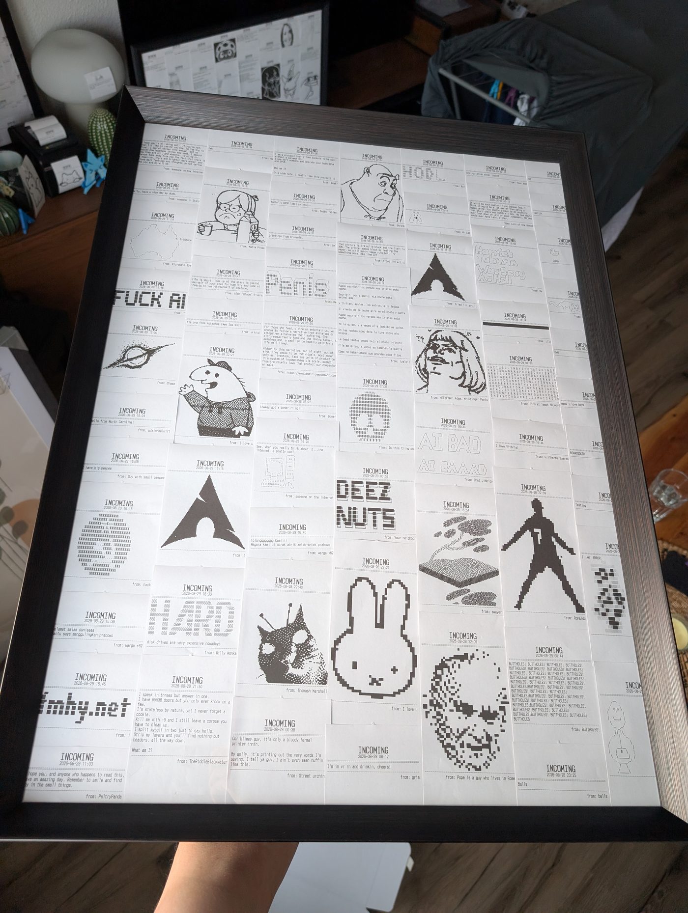 The frame held up at an angle in a living room, with a second smaller framed collage visible behind it.