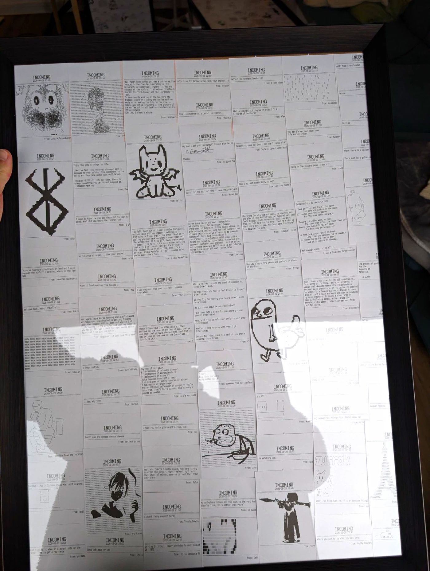 A dark frame of thermal receipts held up indoors. Among them the Berserk brand symbol, a winged cat, dense blocks of text including Jabberwocky, and a figure with a rocket launcher.