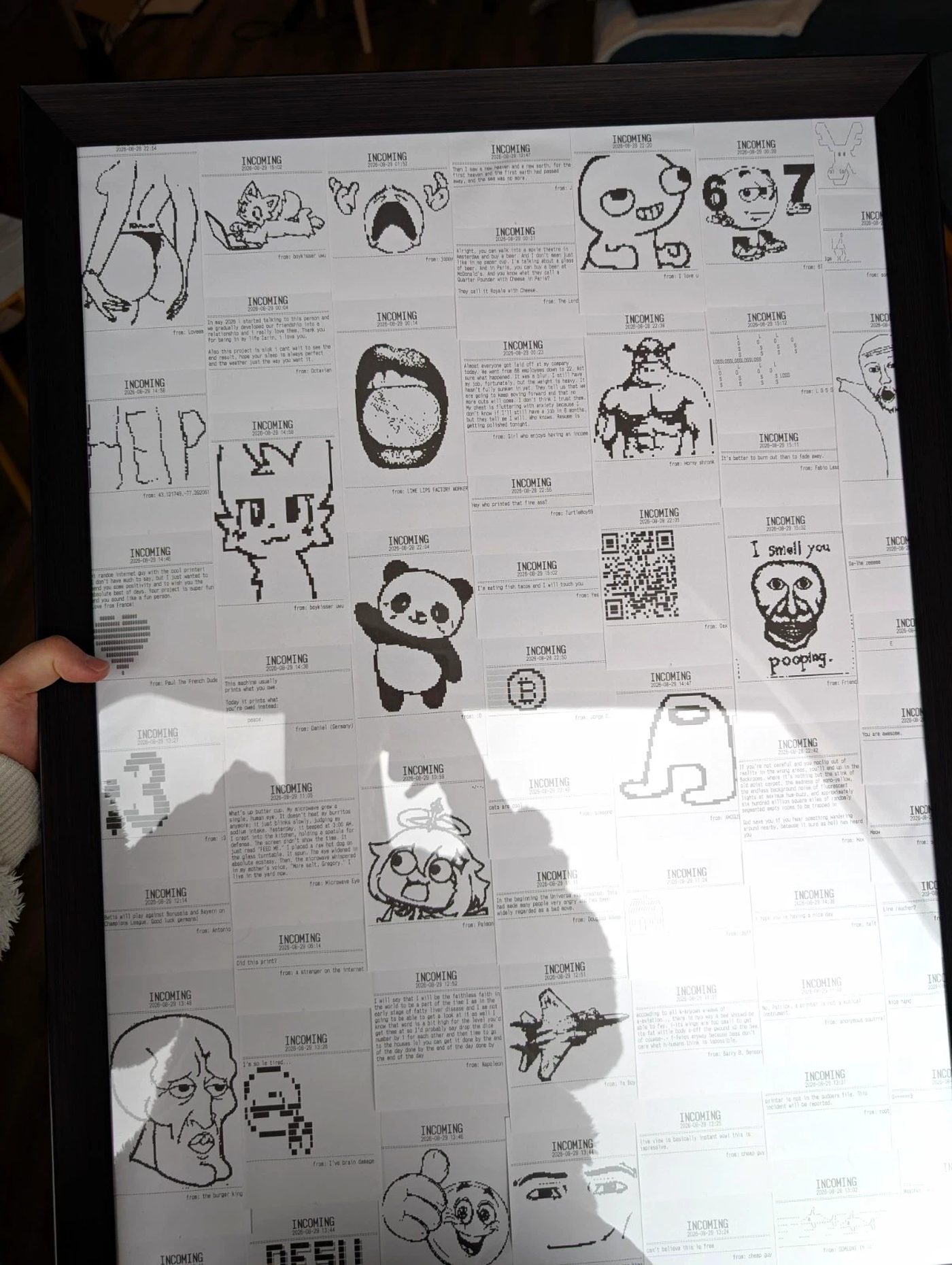 A dark frame of thermal receipts held up indoors. Among them the word HELP in outline, a panda, Squidward, an Among Us crewmate, a fighter jet and several QR codes.